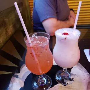 a man sitting at a table with two drinks