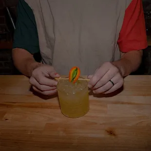 a man holding a drink and a toothpick