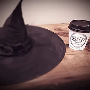 a cup of coffee and a witch&apos;s hat