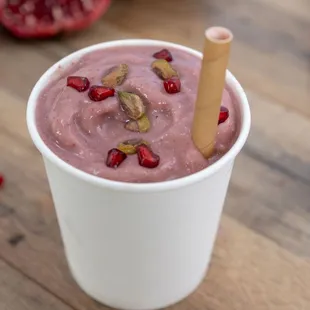 a pomegranate smoothie in a paper cup