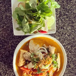 a bowl of soup and a plate of salad