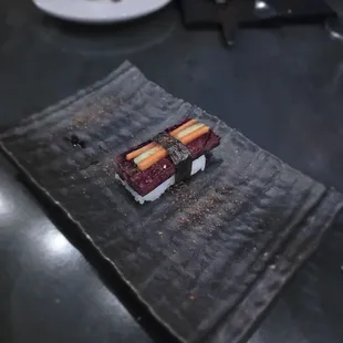 Brown sugar cured soy glazed pork belly musubi, seasoned rice, cucumber, carrot, tomato