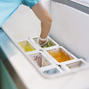 a person reaching for a scoop of ice cream