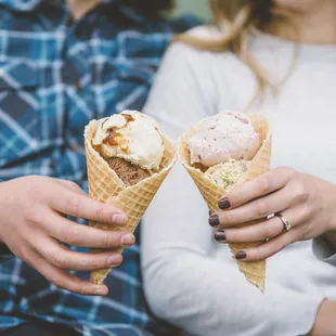 two people holding ice cream cones