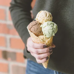 a person holding a cone of ice cream