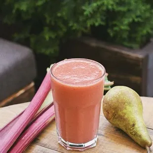 a smoothie and a pear on a table