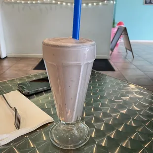 a chocolate milkshake with a blue straw