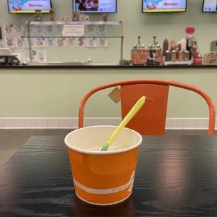 a plastic cup with a yellow straw sitting on a table