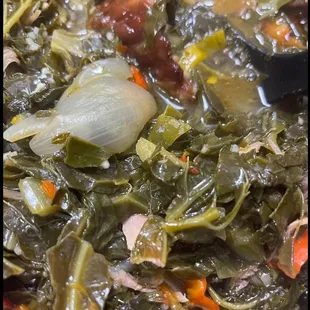 a bowl of stew with greens and onions