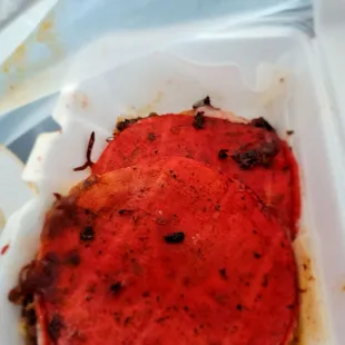 a piece of pizza in a styrofoam container