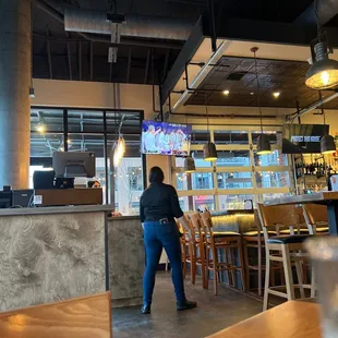 a woman standing at a counter in a restaurant