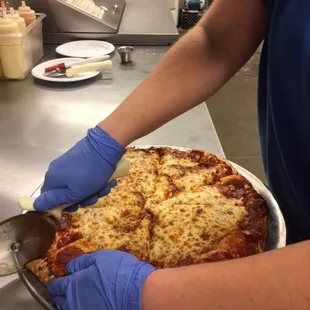 a person cutting a pizza