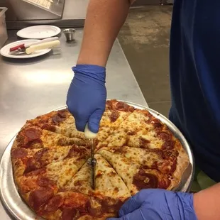 a person cutting a pizza