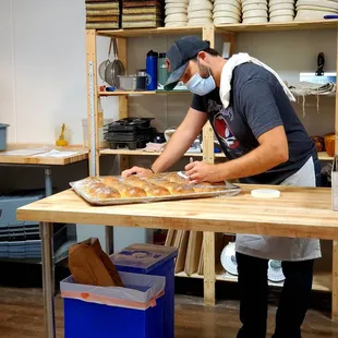 a man in a mask and apron making bread