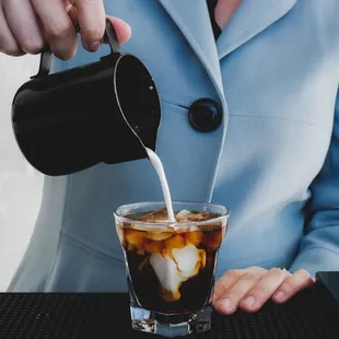 a woman pouring milk into a glass