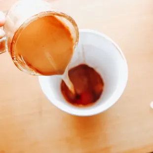 a person pouring coffee into a cup