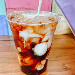 a glass of iced coffee with a straw