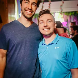 a man in a blue shirt and a man in a blue shirt standing next to each other