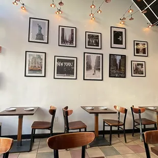 a dining area with tables, chairs, and pictures on the wall