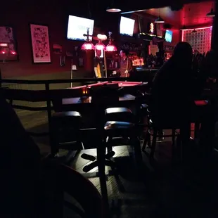 people sitting at the bar watching tvs