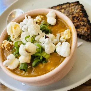 Vegan Brentwood Corn Chowder with roasted corn, onion, Yukon gold potatoes, queso fresco, cilantro, & popcorn