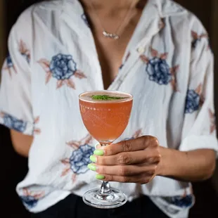 a woman holding a cocktail