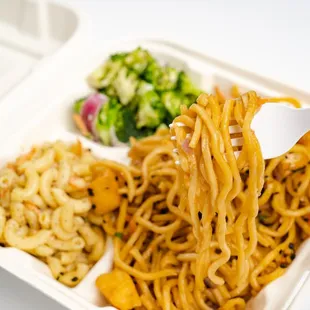 a take out container with noodles and broccoli