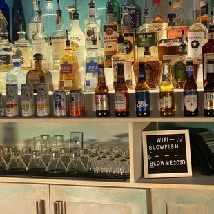 a shelf of liquor bottles and glasses