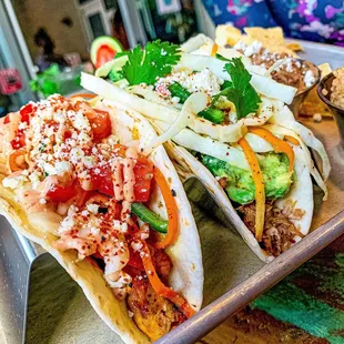 a plate of tacos with a variety of toppings