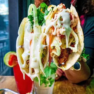 a woman holding up a large taco