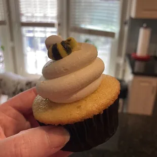 a hand holding a cupcake