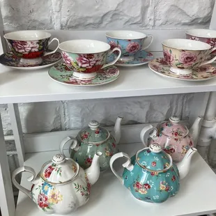 a shelf of teapots and teacups
