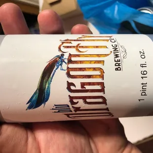 a hand holding a can of beer