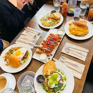 a woman sitting at a table with plates of food