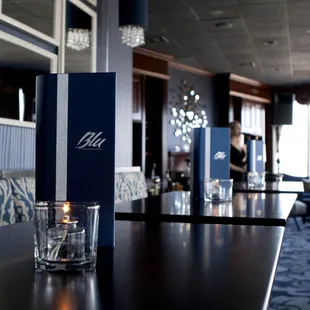 a candle and a menu on a table in a restaurant