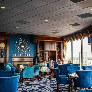 two women sitting in blue chairs in a hotel lobby