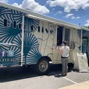 a woman standing in front of a food truck