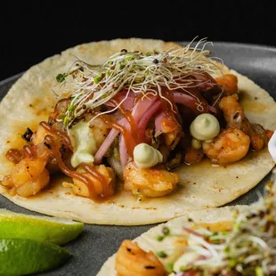 Shrimp and Belly . 
Shrimp and pork belly, aple marmalade, avocado mousse, red pickled onion, and cilantro, Served on corn torilla