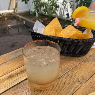 a drink and chips on a wooden table