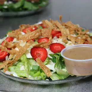 a salad with strawberries and onion rings