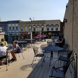 people sitting at tables on a patio
