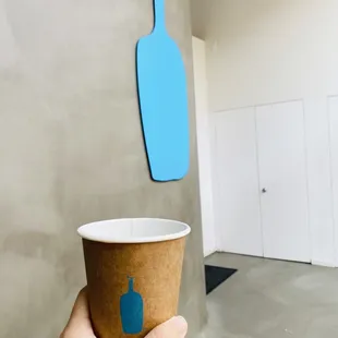 a hand holding a paper cup