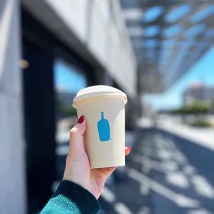 a hand holding a coffee cup