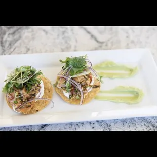 Shrimp tostadas with avocado purée topped with Mexican salad
