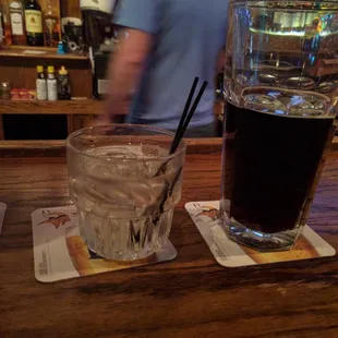 a glass of soda and a drink on a bar