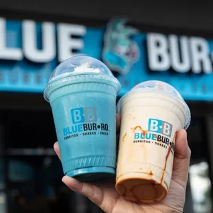 a hand holding two drinks