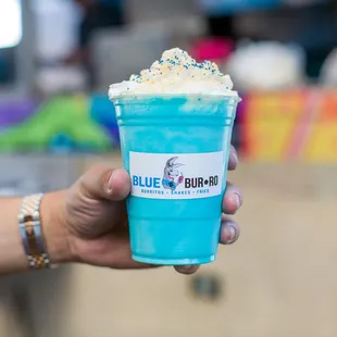 a hand holding a cup of blue burro