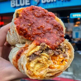 a hand holding a burrito