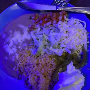 Each person receives a plate of beans, rice, cheese, lettuce, and sour cream.