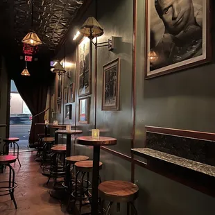 the interior of a bar with stools and tables